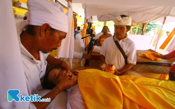 Thumbnail Umat Hindu mengikuti ritual Metatah atau potong gigi massal di Krematorium Setra Ganda Wangi, Kelurahan Talang Jambe, Kecamatan Sukarami Palembang, Sumatera Selatan, Jumat (7/6/2024). Prosesi potong gigi massal yang diikuti sebanyak 14 orang umat Hindu sebagai simbol untuk membersihkan keangkaramurkaan dan keserakahan dari diri seseorang. Ada 6 buah gigi yang dikikis sebagai simbol sad ripu, yaitu 4 buah gigi seri dan 2 buah gigi taring. (Wahyu Rahmanto/Ketik.co.id)