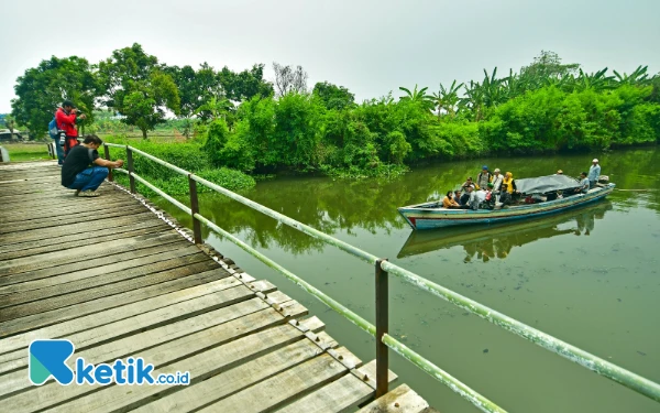 Thumbnail Beberapa insan pers mengabadikan sejumlah petugas gabungan di atas perahu tradisional yang sedang melaju untuk mendistribusikan logistik Pilkada serentak 2024 menuju TPS 11 di Dusun Pucukan, Desa Gebang, Kecamatan Sidoarjo, Kabupaten Sidoarjo, Jawa Timur pada Selasa 26 November 2024. Selain memotret, sebagian insan pers juga turut mengawal proses distribusi membersamai petugas gabungan di atas perahu tradisional. (Foto: Achmad Fazeri/Ketik.co.id)